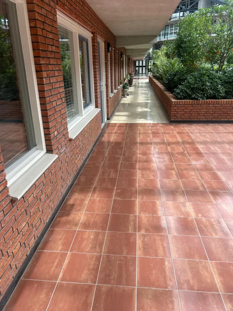 Schoongemaakte galerij met terracotta tegels langs de woningen