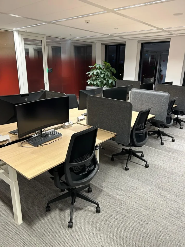 Schoongemaakte kantoorruimte met bureaus en vloerbedekking