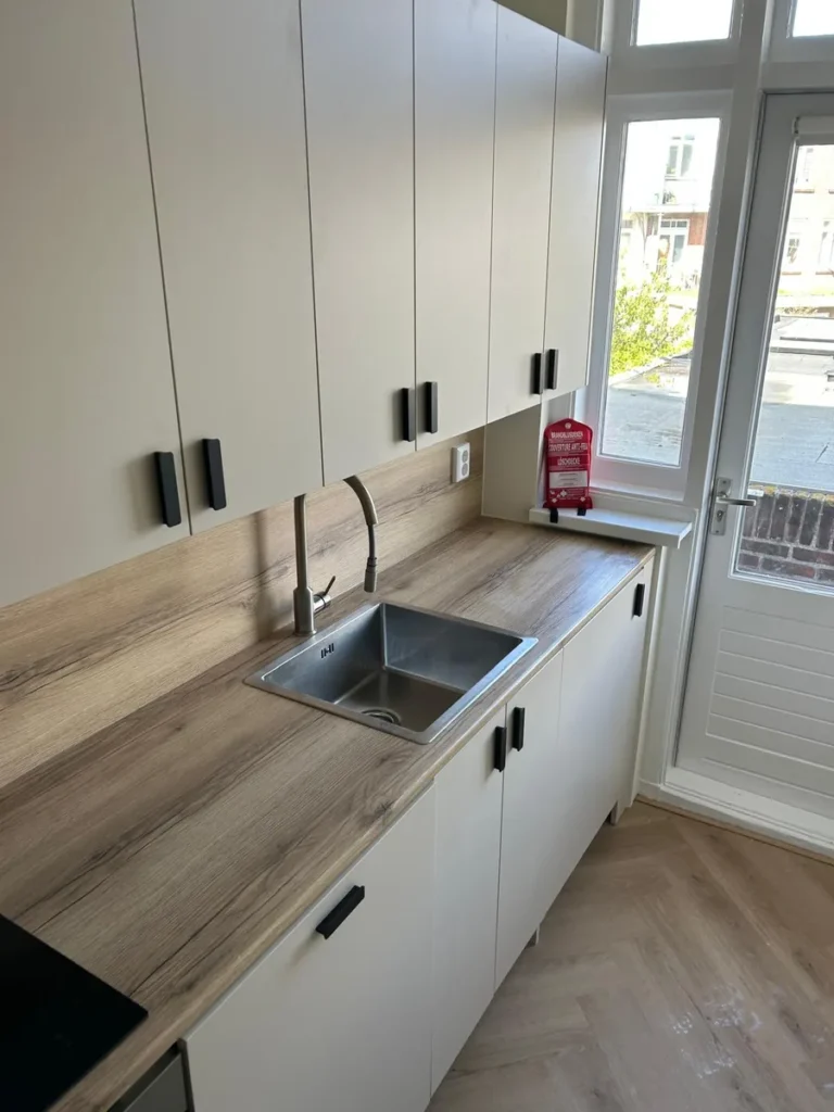 Schoongemaakte pantry met aanrecht, spoelbak en keukenkastjes