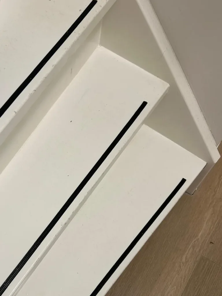 Schoongemaakt trappenhuis met witte treden en antislipstrips